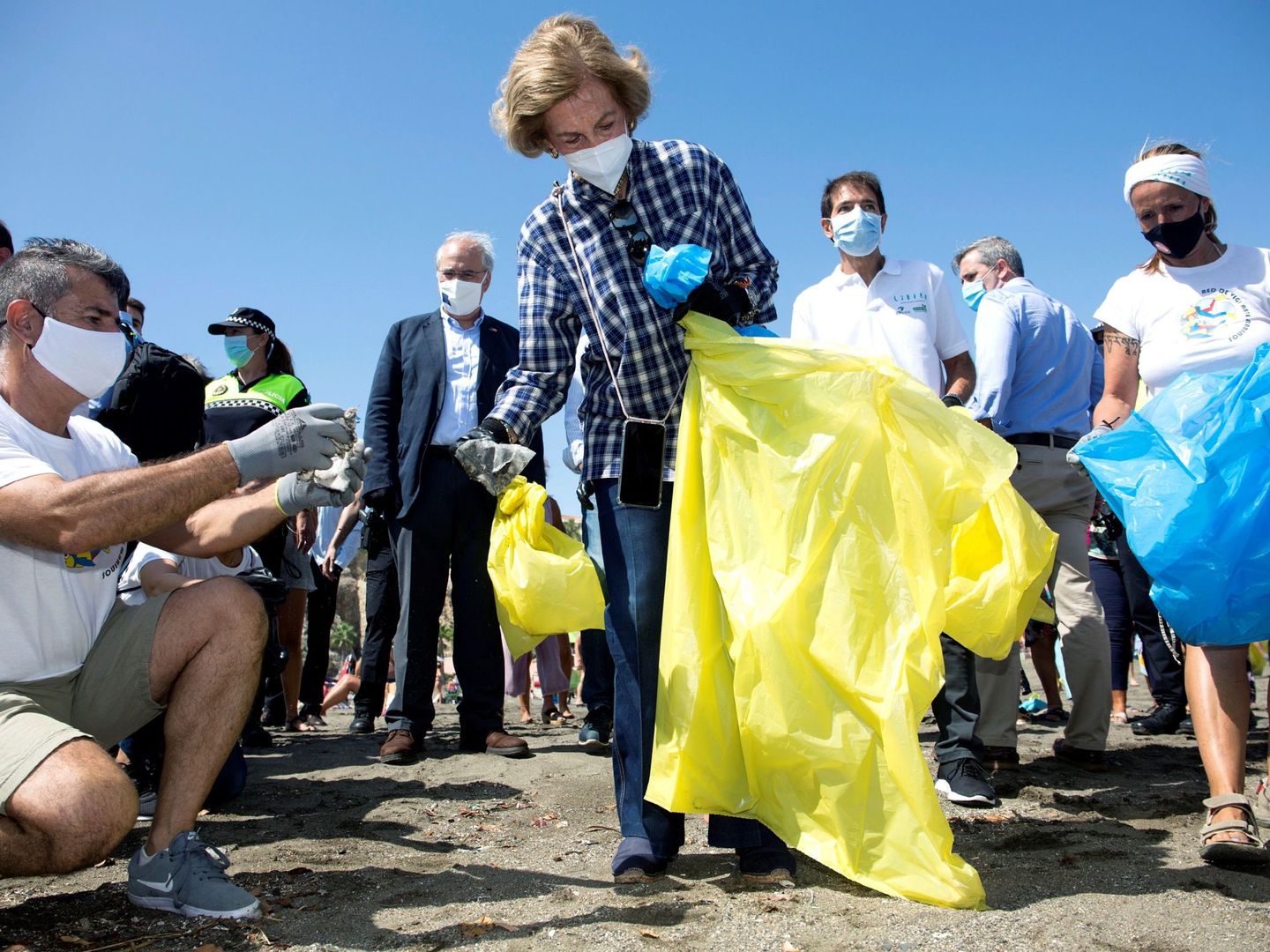 La reina Sofía en Málaga, colaborando en tareas de recogida de residuos en la playa. (EFE)