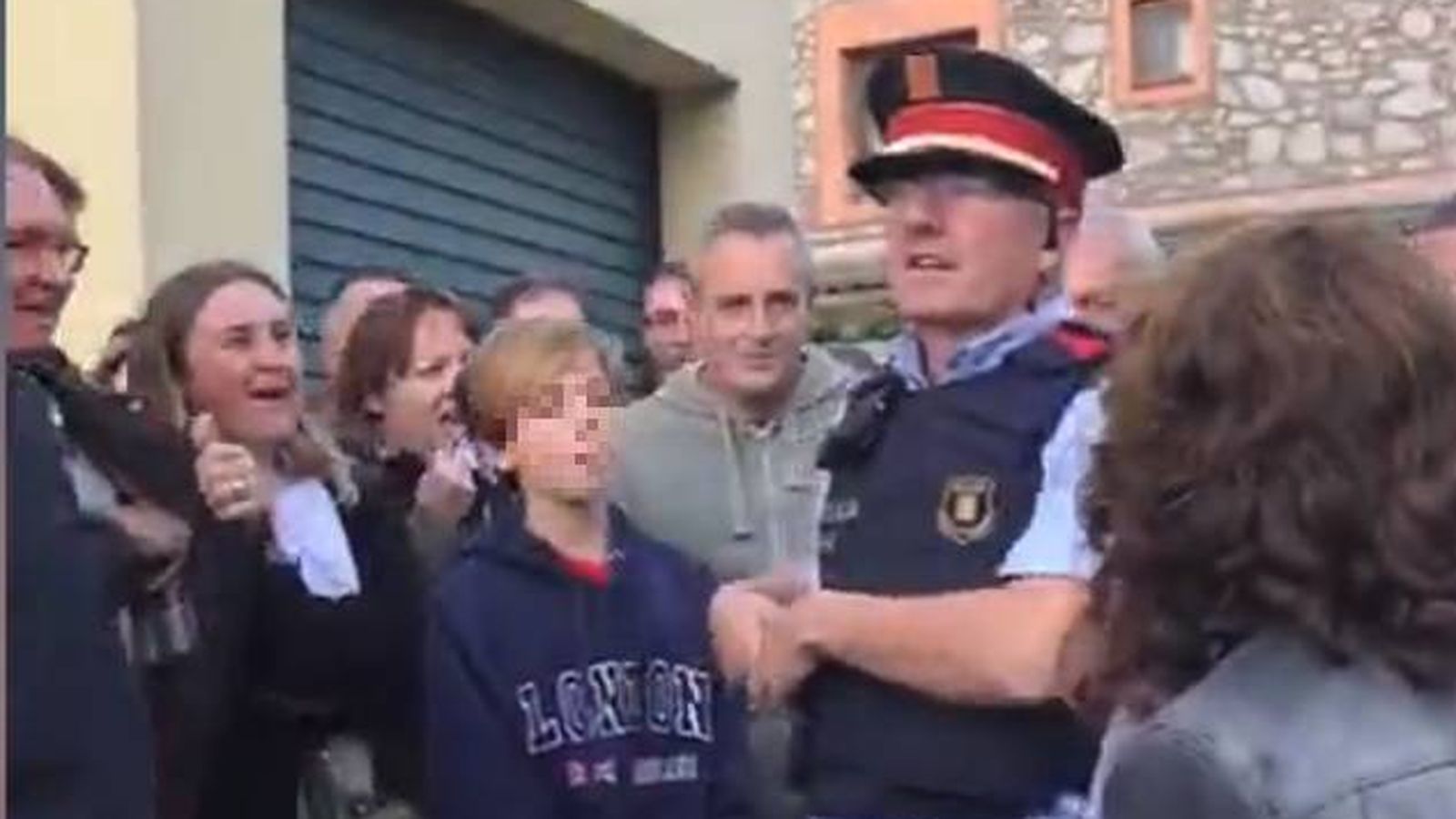 Foto:  Uno de los mossos informa a los votantes de la orden que tienen de entrar. (EC)