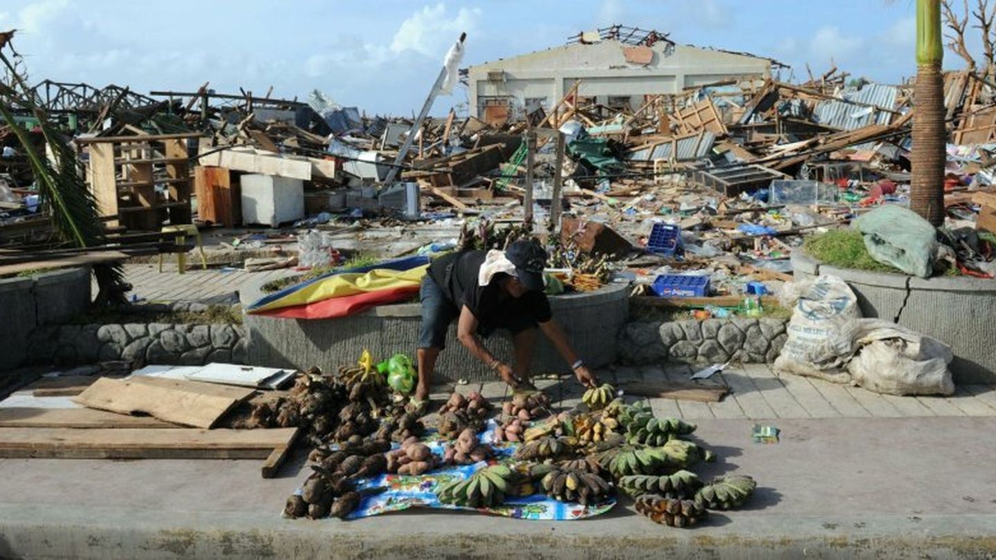Un hombre vende comida junto a un mercado destrozado por el tifón en Guiuan (Reuters)