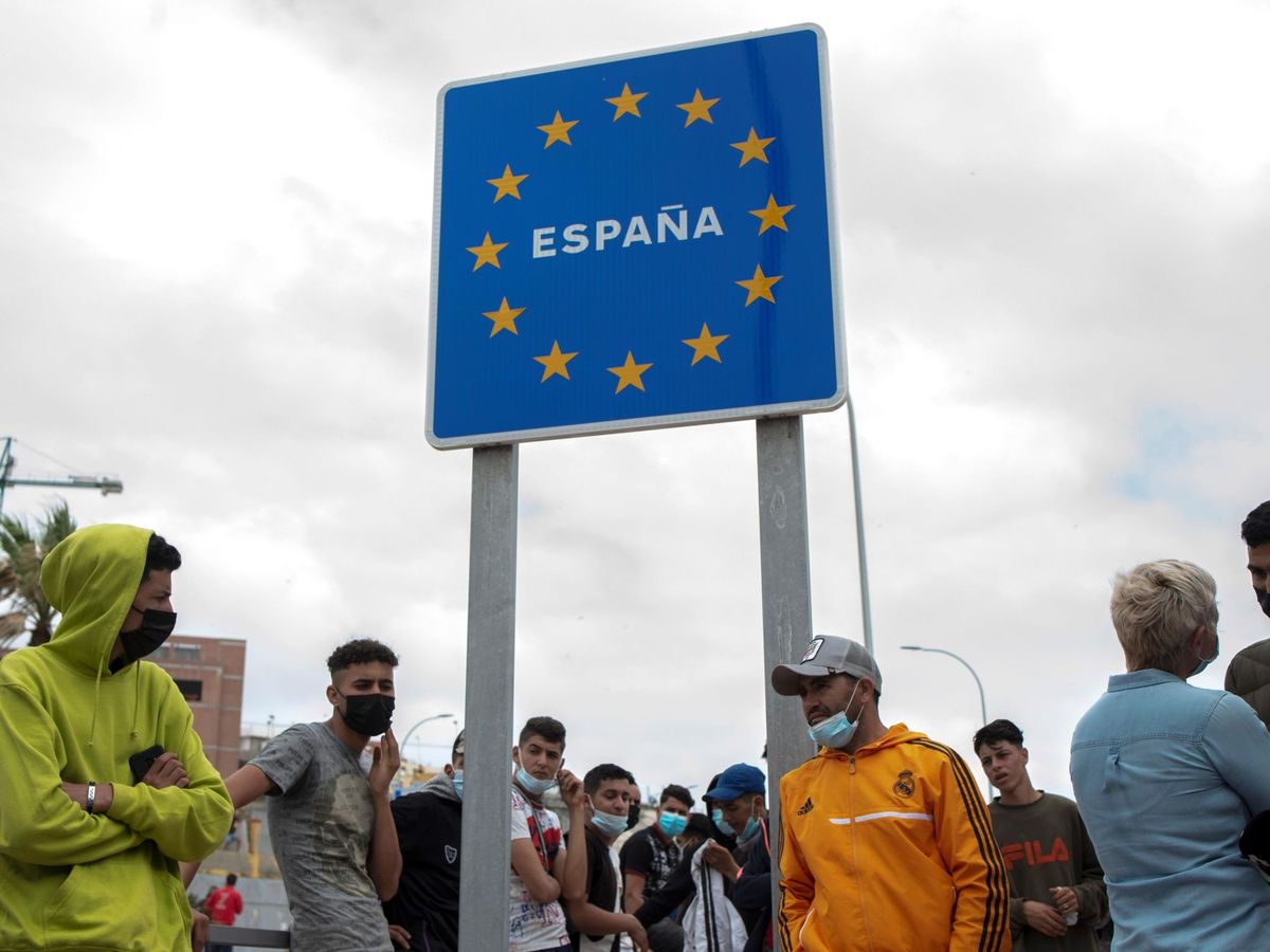 Foto: Varios migrantes esperan para pasar la frontera entre Ceuta y Marruecos. (EFE)