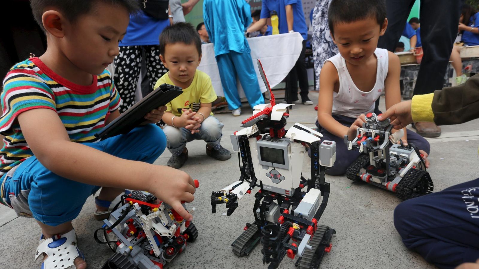 Foto: Niños jugando con robots. (Reuters)