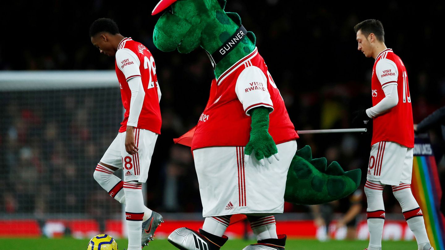 La mascota del equipo, con Ozil a su espalda. (Reuters)