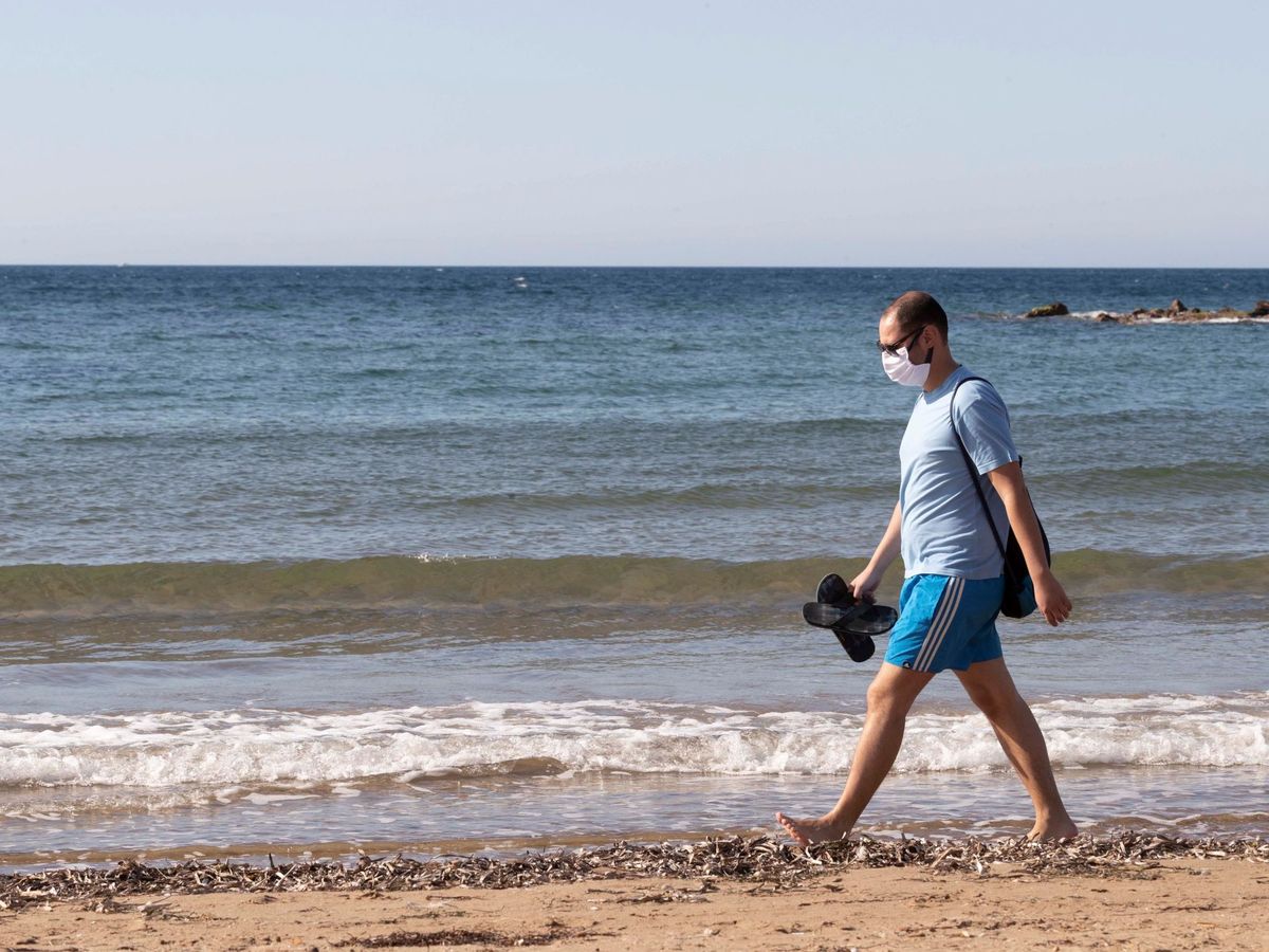 Foto: Un hombre con mascarilla camina por la playa de Rihuete, Mazarrón, en Murcia, este domingo. (EFE)