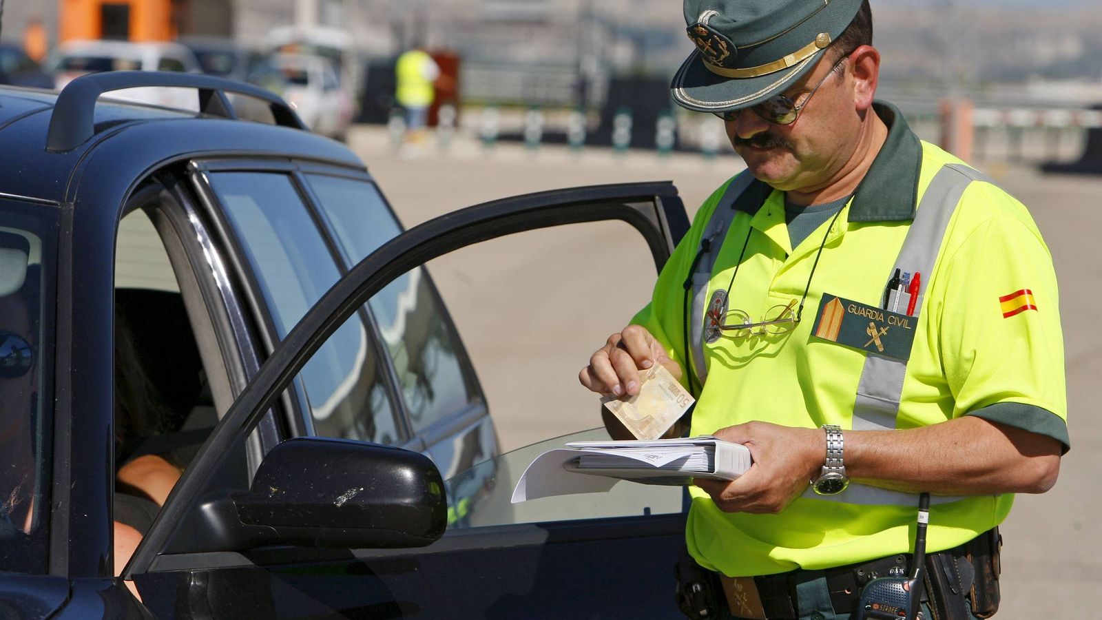 Foto: Un agente de la Guardia Civil notifica una multa a un conductor. (Efe)