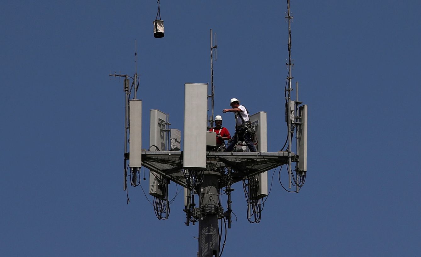Trabajadores instalando una torre 5G. (Reuters)