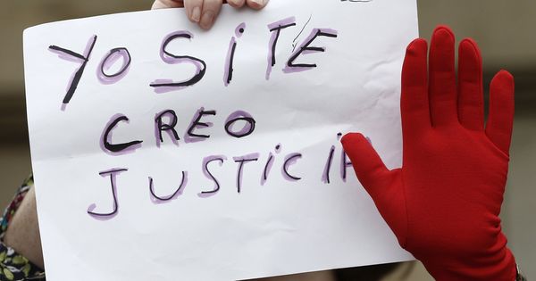 Foto: Una mujer porta un cartel contra la sentencia que condena a La Manada por abuso sexual y no por agresión sexual durante una protesta en Pamplona. (EFE)