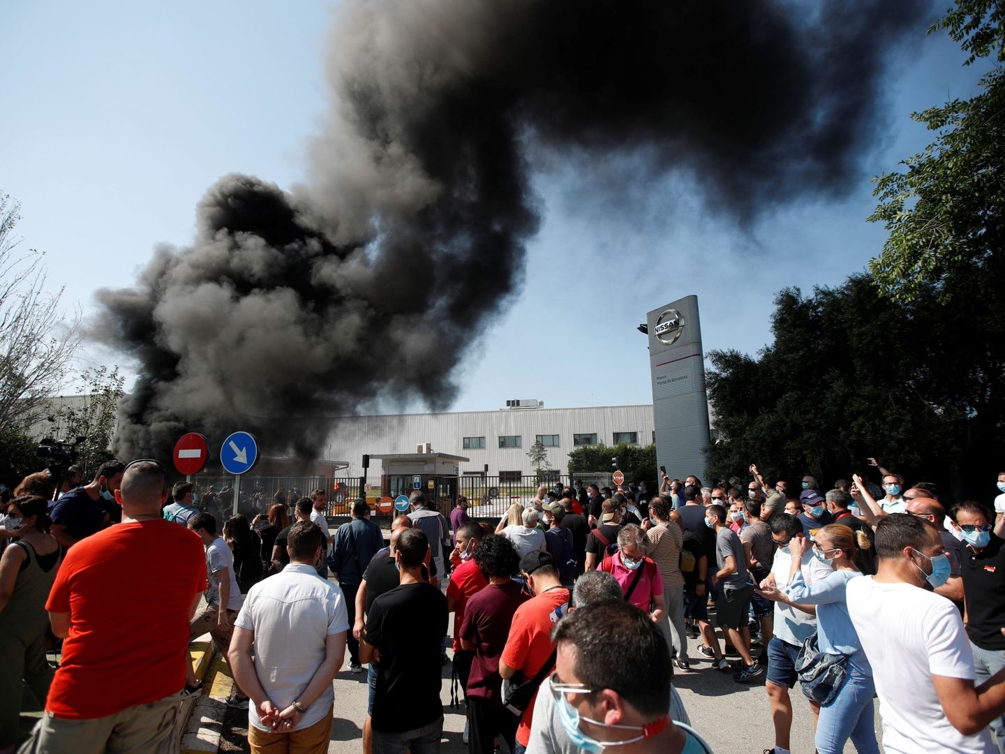 Trabajadores de la fábrica de Nissan, manifestándose por su cierre quemando neumáticos. (EFE)