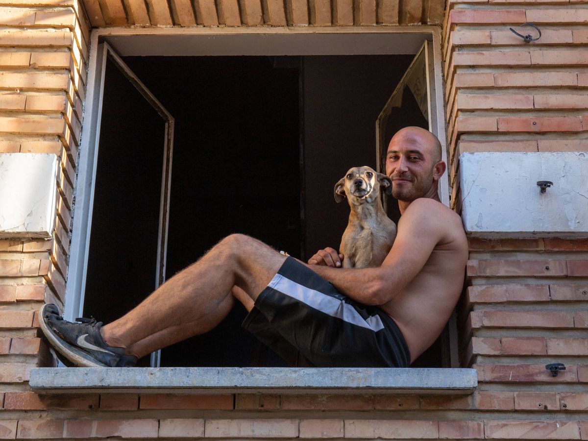 Foto: Juan abraza a su perra en un alféizar de la cárcel vieja de Palma. (David Brunat)