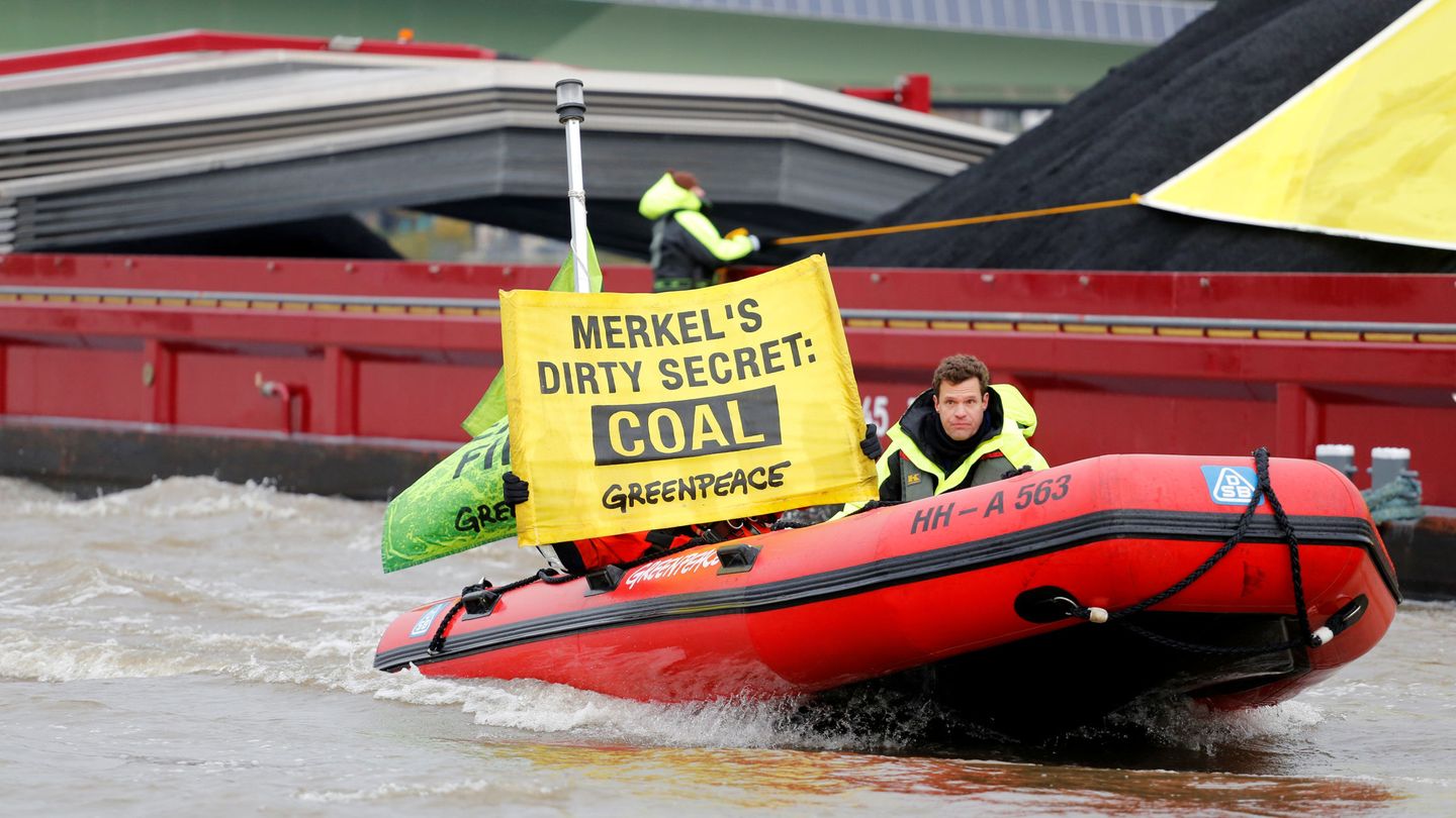 Activistas de Greenpeace muestran pancartas en una lancha por el río Rin (Reuters)