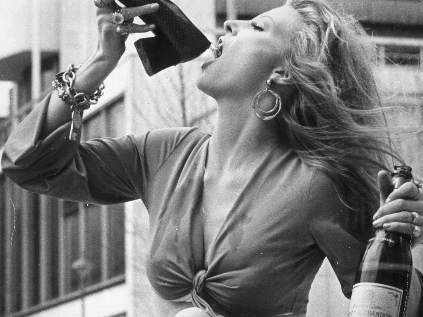 La modelo Vicki Hodge, bebiendo champán con su melena al viento. (Getty)