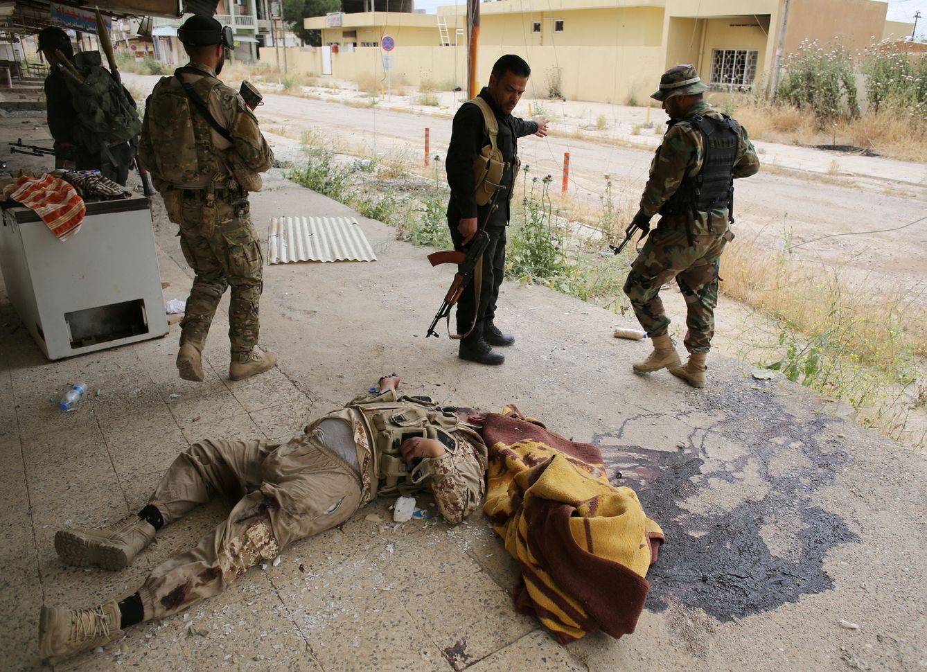 Combatientes peshmerga observan el cadáver de un militante del Daesh en Tel Asof, el 4 de mayo de 2016 (Reuters)