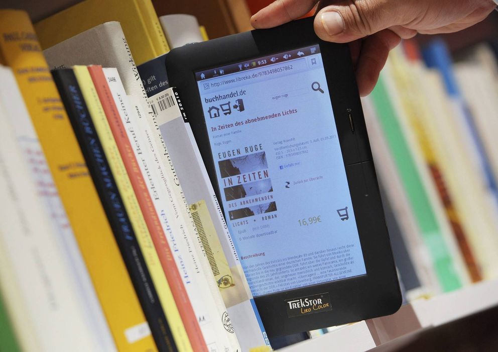 Foto: Una persona observa un libro electrónico en un estante. (EFE)