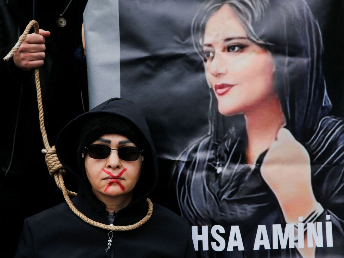 Foto: Una mujer protestando ante un cartel de Mahsa Amini. (Reuters/Dilara Senkaya)