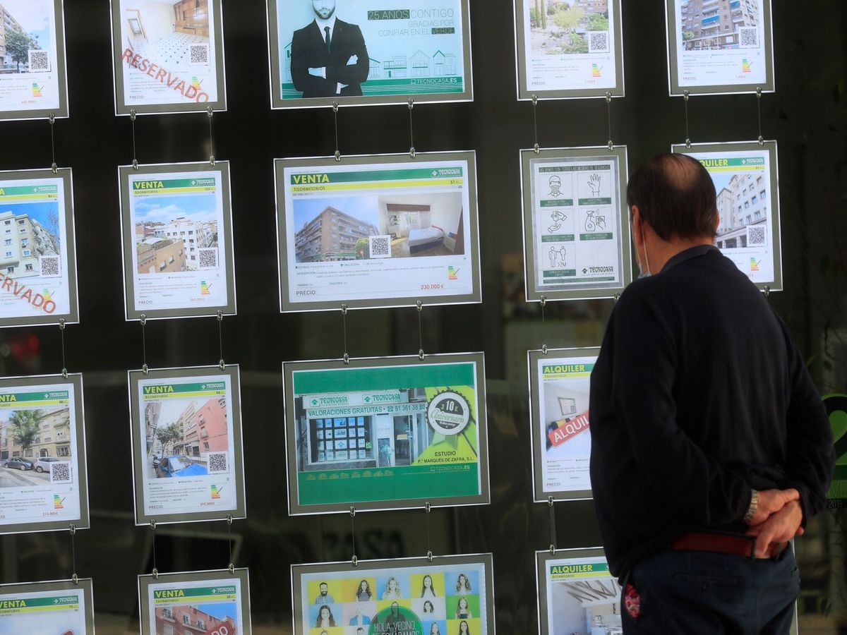 Foto: Un hombre mira unos carteles en una inmobiliaria de Madrid. (EFE) 