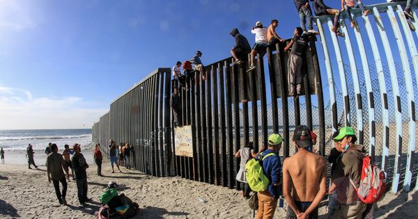 Foto: Migrantes escalan el muro fronterizo hoy en Tijuana, en el estado de Baja California (México). (EFE)