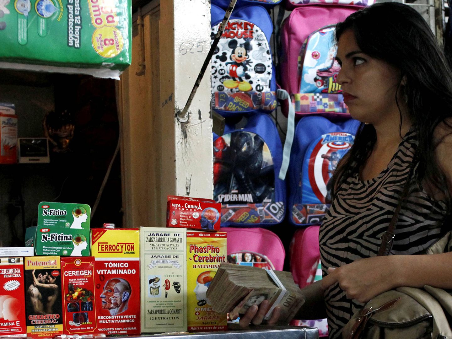 Una mujer sostiene un fajo de bolívares en un mercado en Rubio, Venezuela. (Reuters)