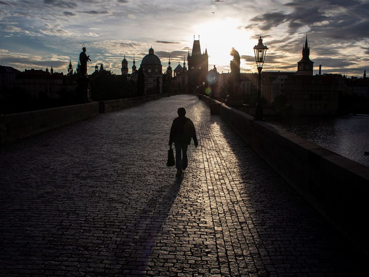 Foto: Un hombre cruza el Puente Carlos al amanecer este lunes en Praga. (EFE)