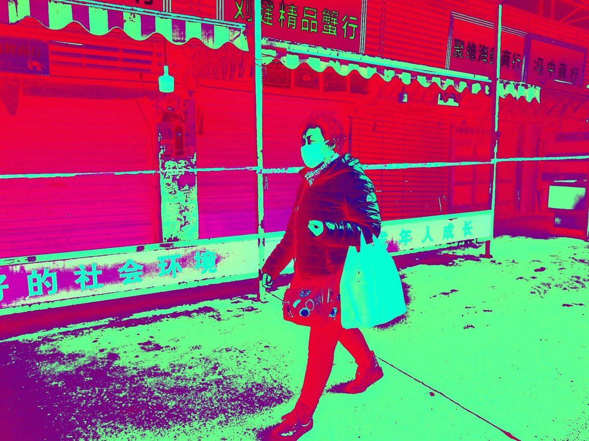 Foto: Una mujer con mascarilla en el mercado cerrado de Huanam. (EFE)