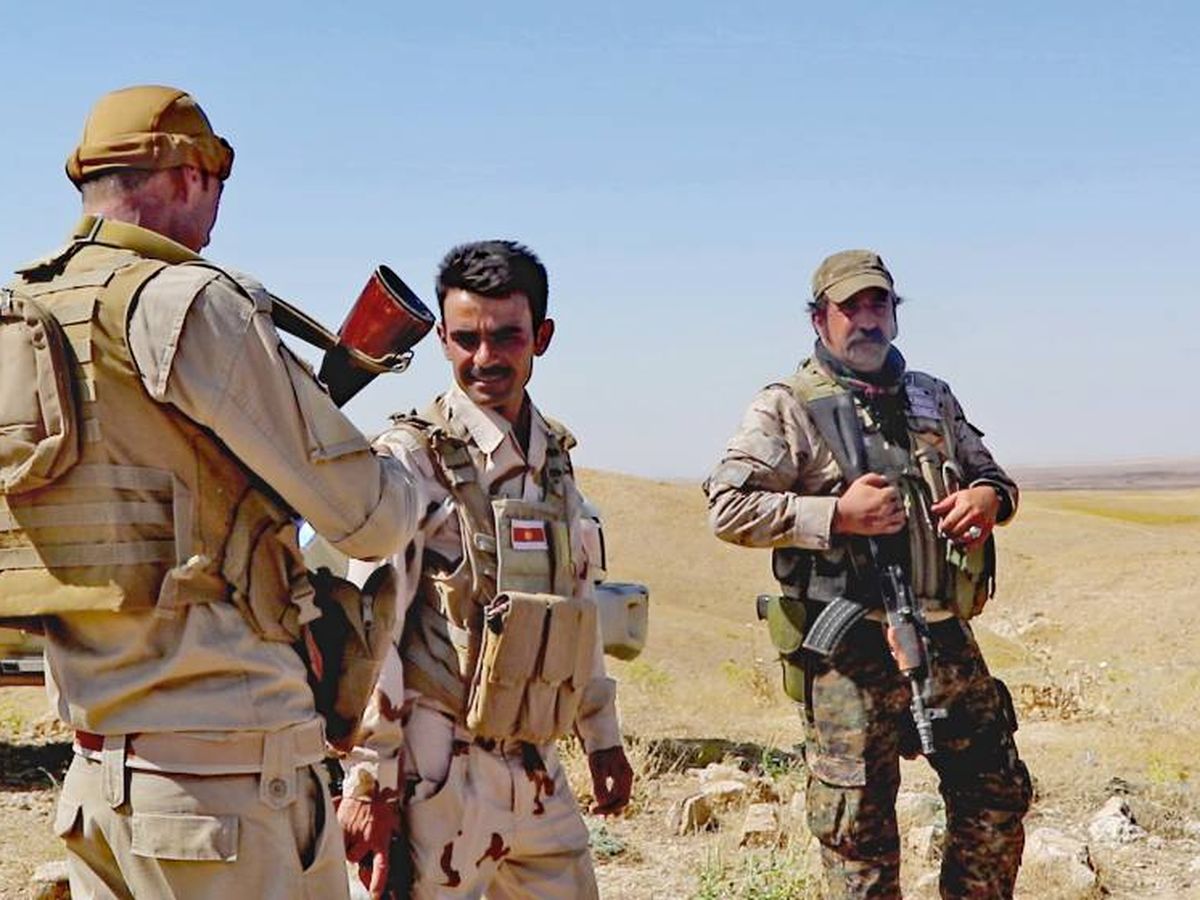 Foto: Milicianos de la unidad yazidí de Haydar Shasho (primer plano), junto a un excapitán del Ejército español que se ha reenganchado varias veces en las YBS. (Ferran Barber)