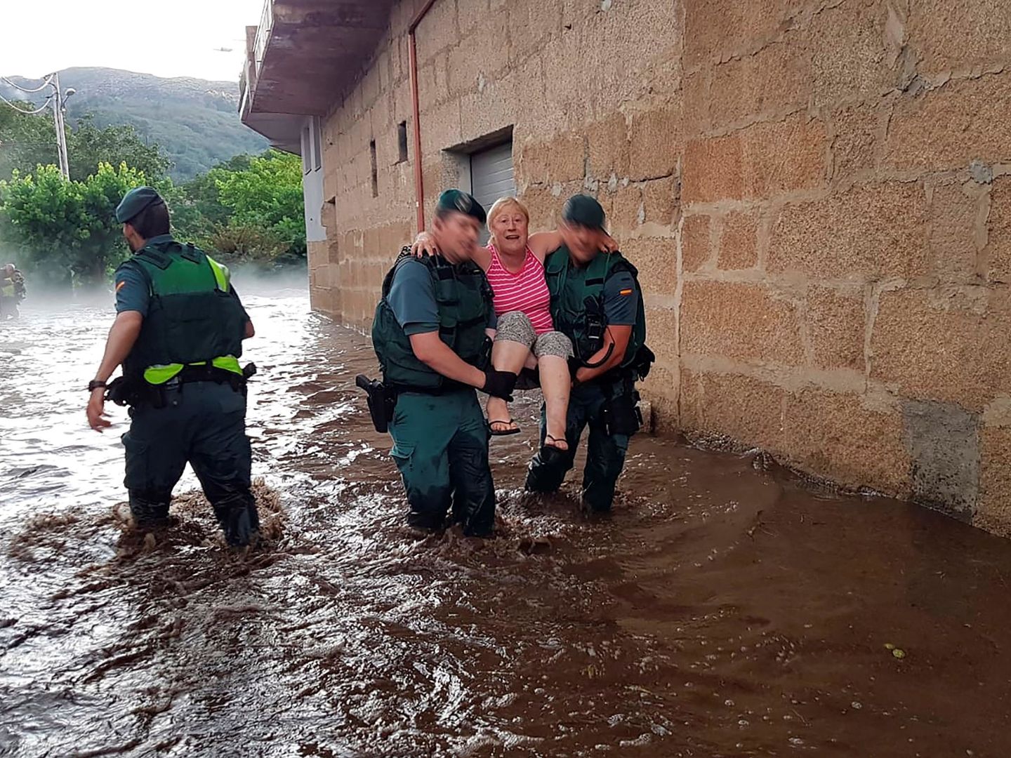 Agentes de la Guardia Civil trasladan a una vecina de Infesta, en Monterrei (Ourense), tras la riada. (EFE)