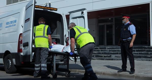 Foto: Miembros del servicio judicial retiran el cadáver del hombre que ha sido abatido esta mañana al intentar acceder a la comisaría de los Mossos de Cornellà con un cuchillo en la mano. (EFE)