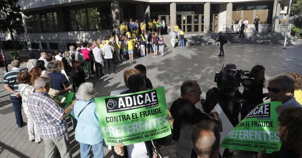 Foto: Afectados por las participaciones preferentes de Caja Madrid hacen cola frente a los juzgados. (EFE) 