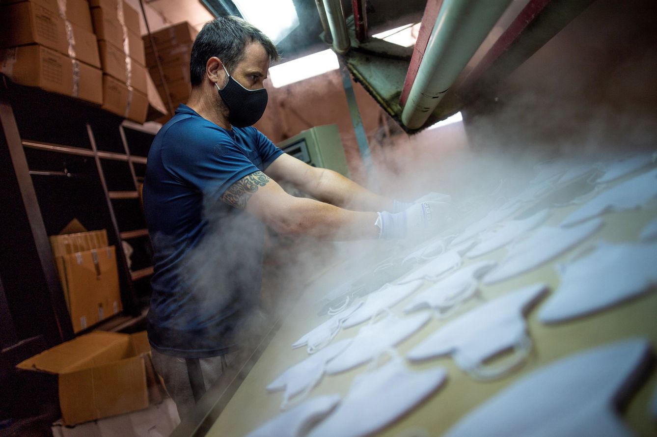 Un empleado fabrica mascarillas en una fábrica de la localidad toledana de Sonseca. (EFE)