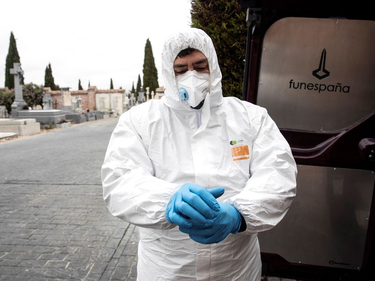 Foto: Un empleado funerario se protege para proceder al traslado de una persona fallecida por coronavirus, este martes, en el cementerio de Pozuelo de Alarcón, Madrid. (EFE)