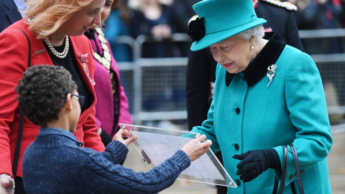 Isabel II de Inglaterra recibe un dibujo de un niño durante la inauguración del centro infantil Queen Elizabeth II de Londres en diciembre de 2018. (EFE)