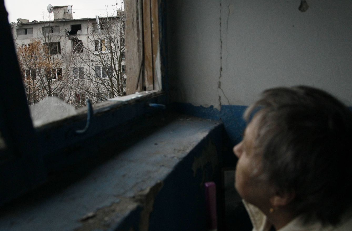 Una mujer observa un bloque de viviendas dañado por el fuego de artillería en Yasynuvata, Ucrania. (Reuters)
