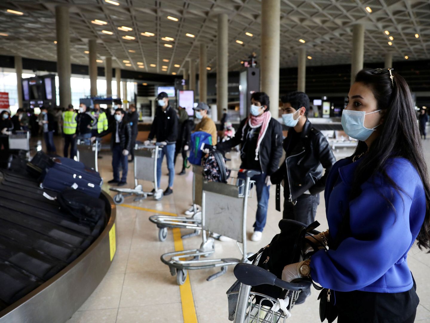 Pasajeros esperan sus maletas en el aeropuerto internacional de Jordania. (Reuters)