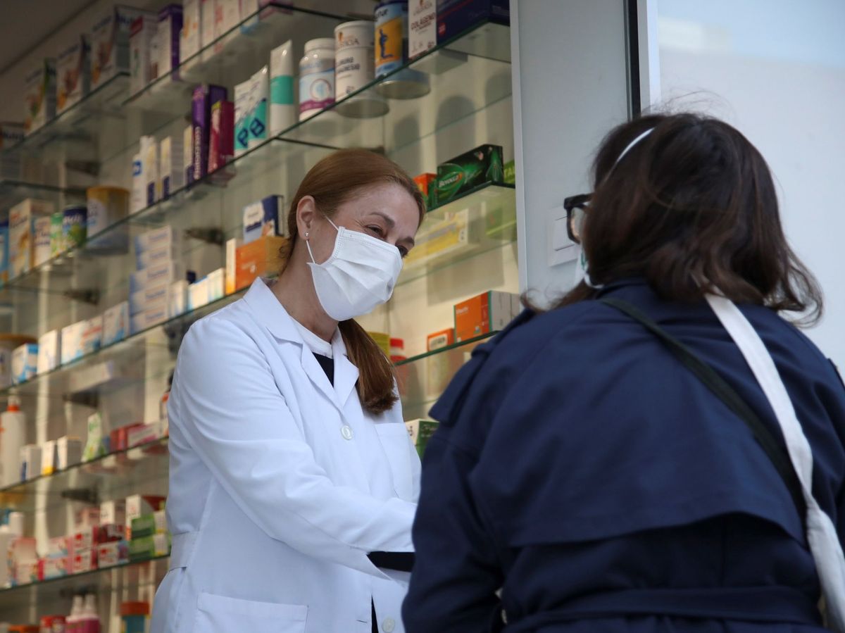 Foto: Una farmacéutica atiende a una cliente en el centro de Madrid (EFE)