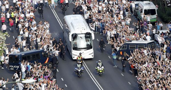 Foto: Los aficionados del Madrid, agolpados recibiendo al autobús. (EFE)