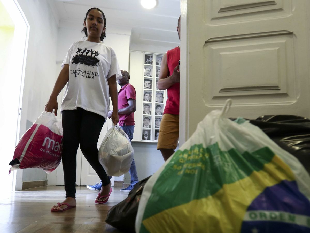 Foto: Un grupo de voluntarios trabaja separando las donaciones que serán enviadas a las familias, tras las tempestades en el litoral del estado brasileño de Sao Paulo. (EFE/Sebastião Moreira)