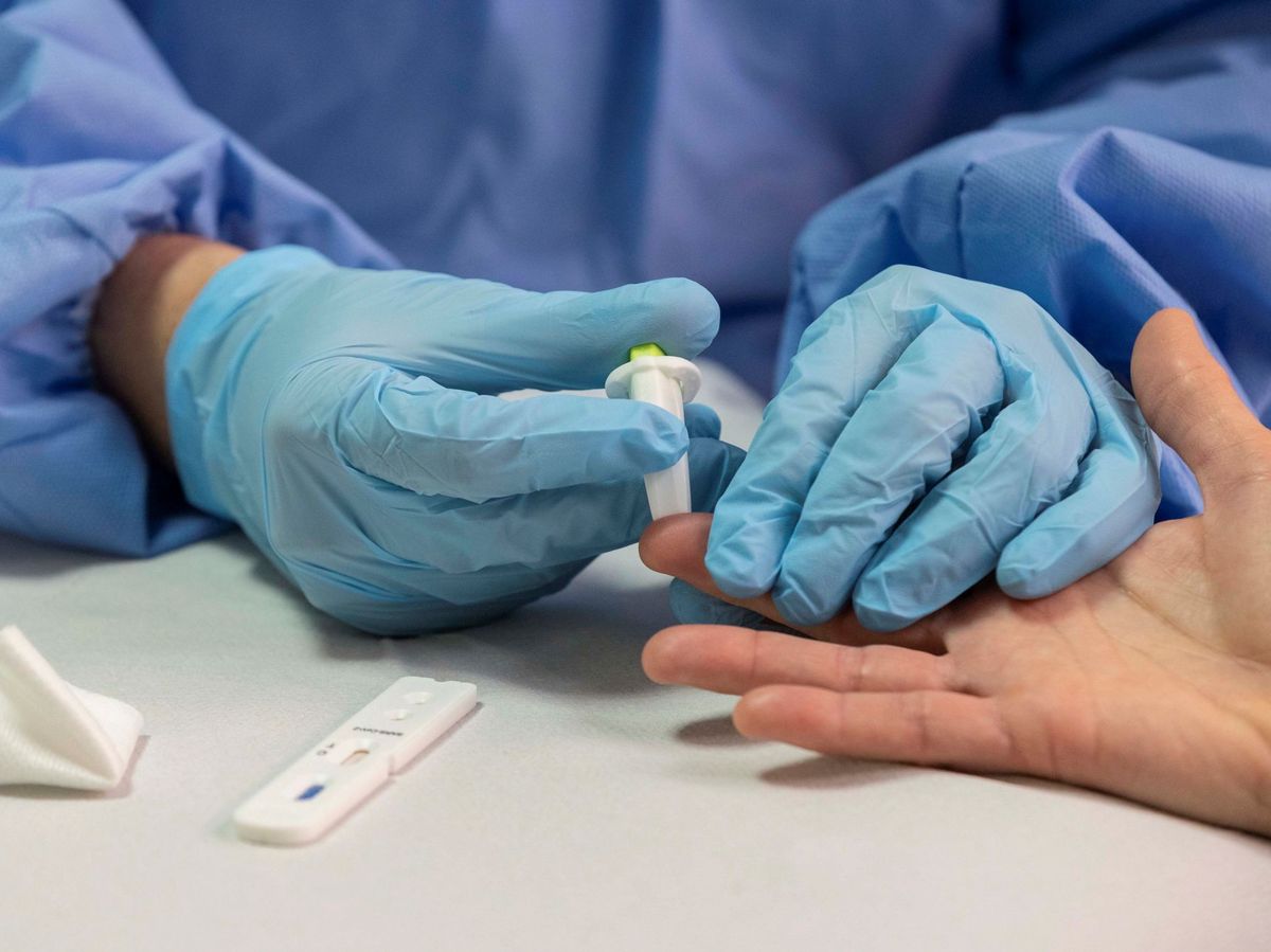 Foto: Una enfermera toma muestras de sangre para hacer un test rápido de coronavirus a una mujer (EFE)