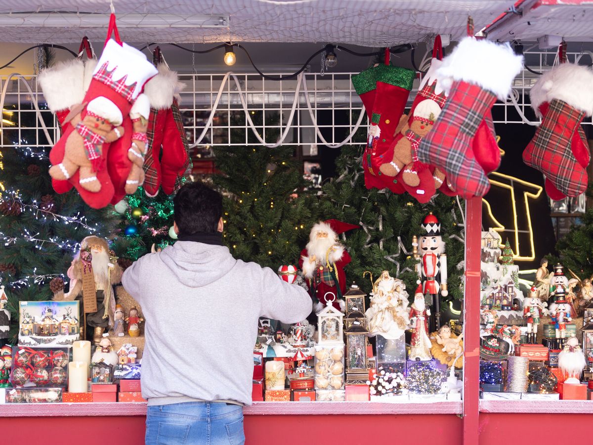 Foto: Un hombre observa una caseta del mercadillo de Navidad, en la Plaza Mayor de Madrid. (Europa Press/Eduardo Parra)