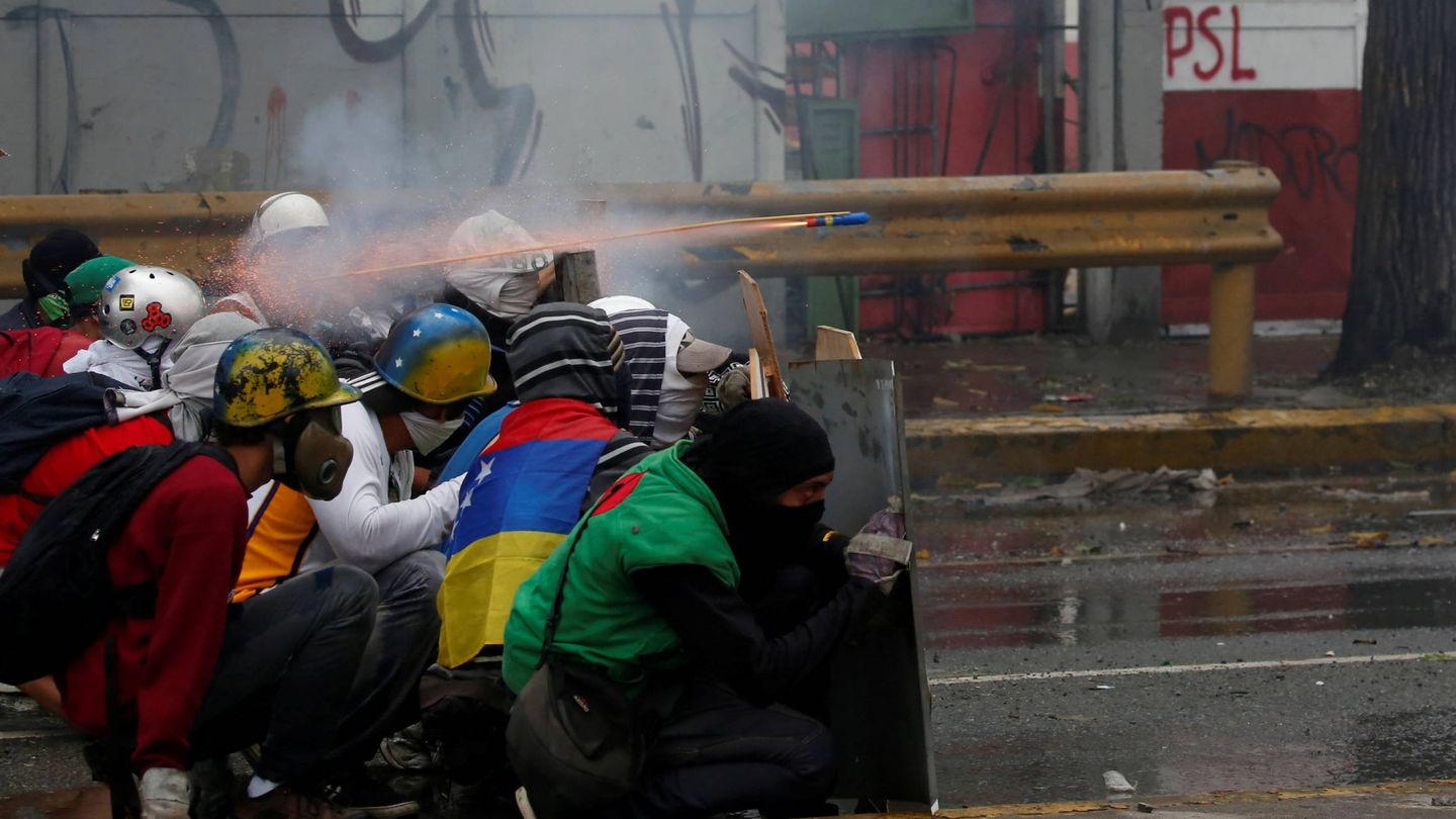 Manifestantes se enfrentan a las fuerzas de seguridad durante una marcha opositora, en Caracas. (Reuters)
