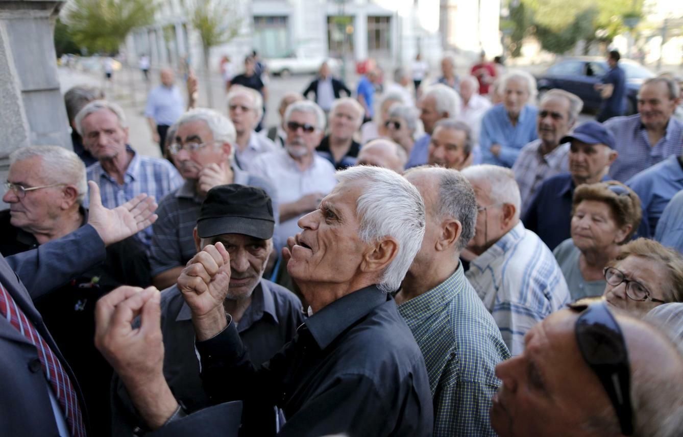 Un pensionista se enfrenta a un trabajador mientras intenta entrar en una sucursal del Banco Nacional de Grecia, en Atenas. (Reuters)