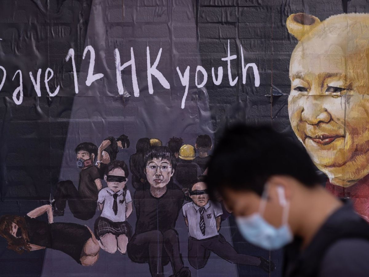Foto: Un estudiante con mascarilla pasa delante de un mural pintado en la Universidad de Hong Kong que recuerda a 12 hongkoneses detenidos en la ciudad china de Shenzhen. (EFE)