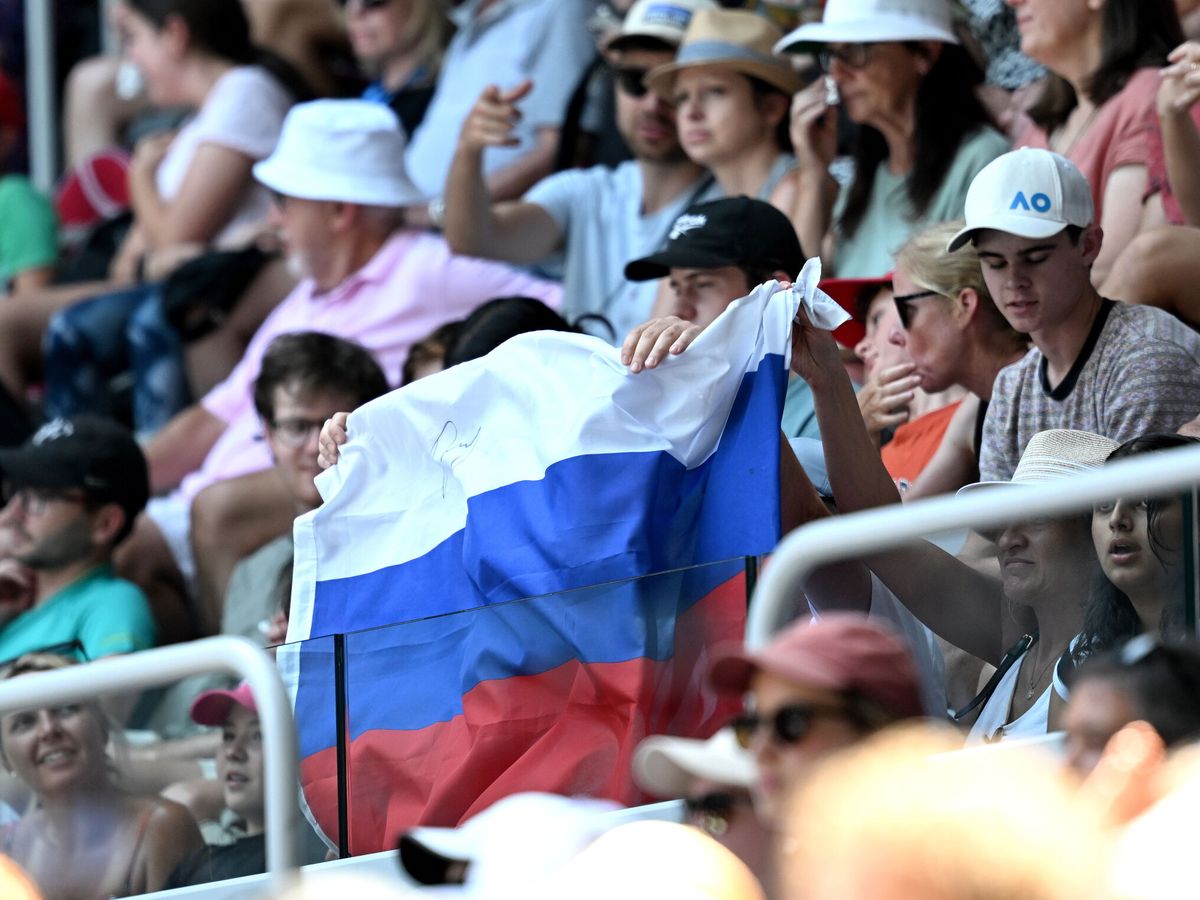 Foto: Aficionados muestran la bandera rusa durante el partido entre Andrey Rublev y Dominic Thiem en el Open de Australia. (EFE/EPA/LUKAS COCH).