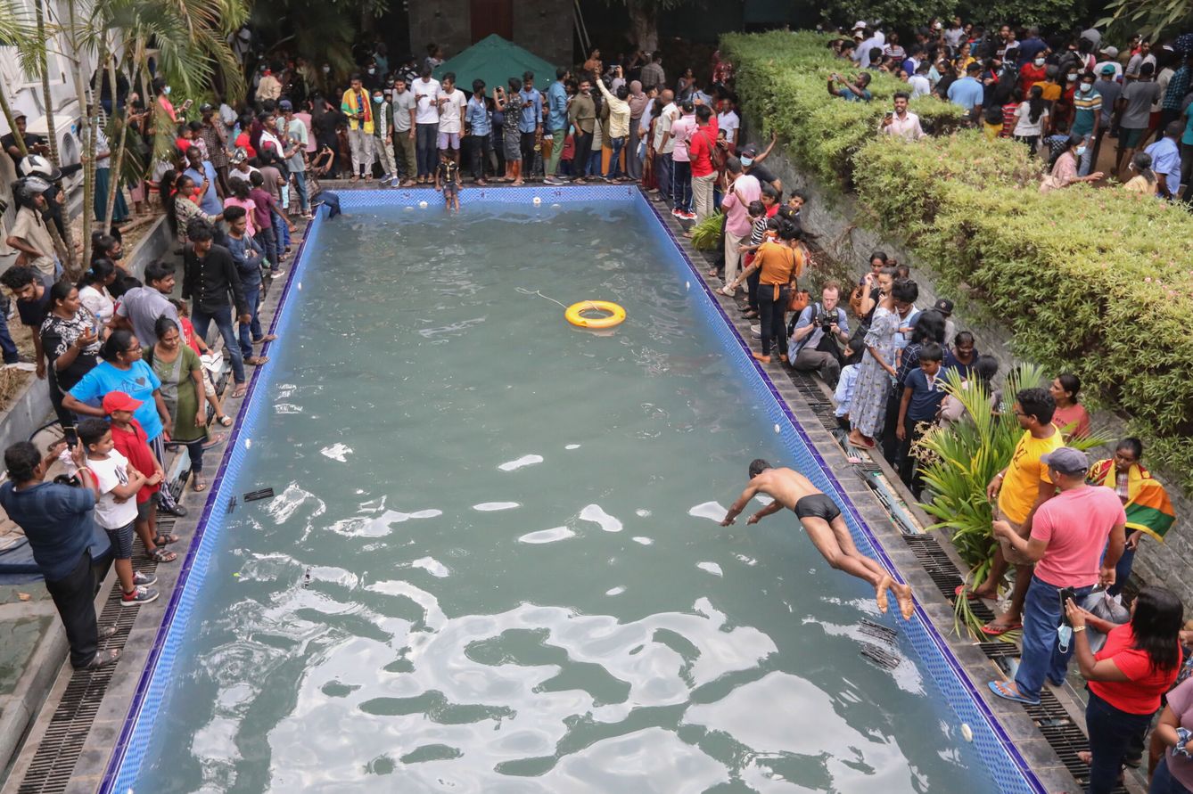 Manifestantes aprovechan y se bañan en la piscina de la residencia del primer ministro en Colombo. (EFE/Chamila Karunarathne)