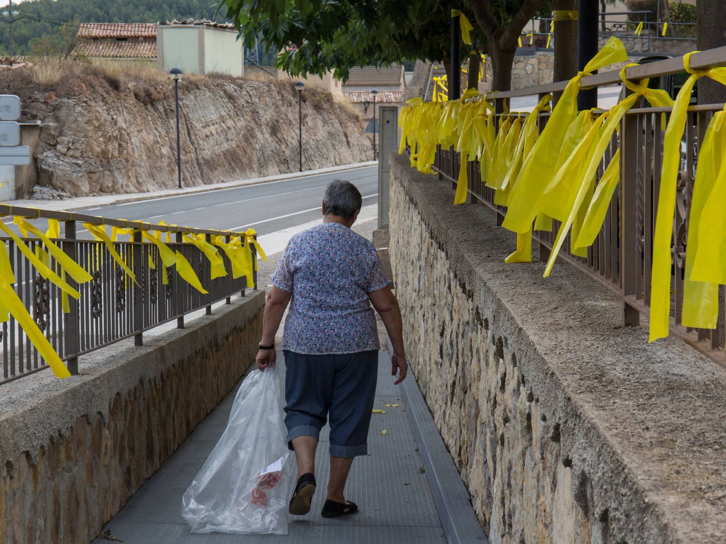 Una mujer camina rodeada de lazos amarillos en Vandellós (Tarragona). (D.B.)