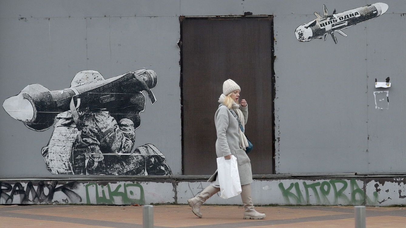Foto: Una mujer pasa junto a una pintada en una pared que representa a un soldado ucraniano lanzando un misil antitanque. (EFE/EPA/Sergey Dolzhenko) 