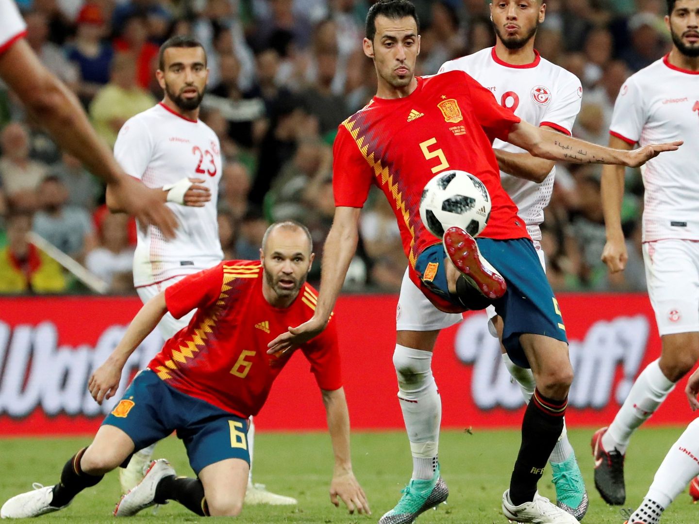 Busquets controla el balón con Iniesta en el suelo ante Túnez. (Efe)