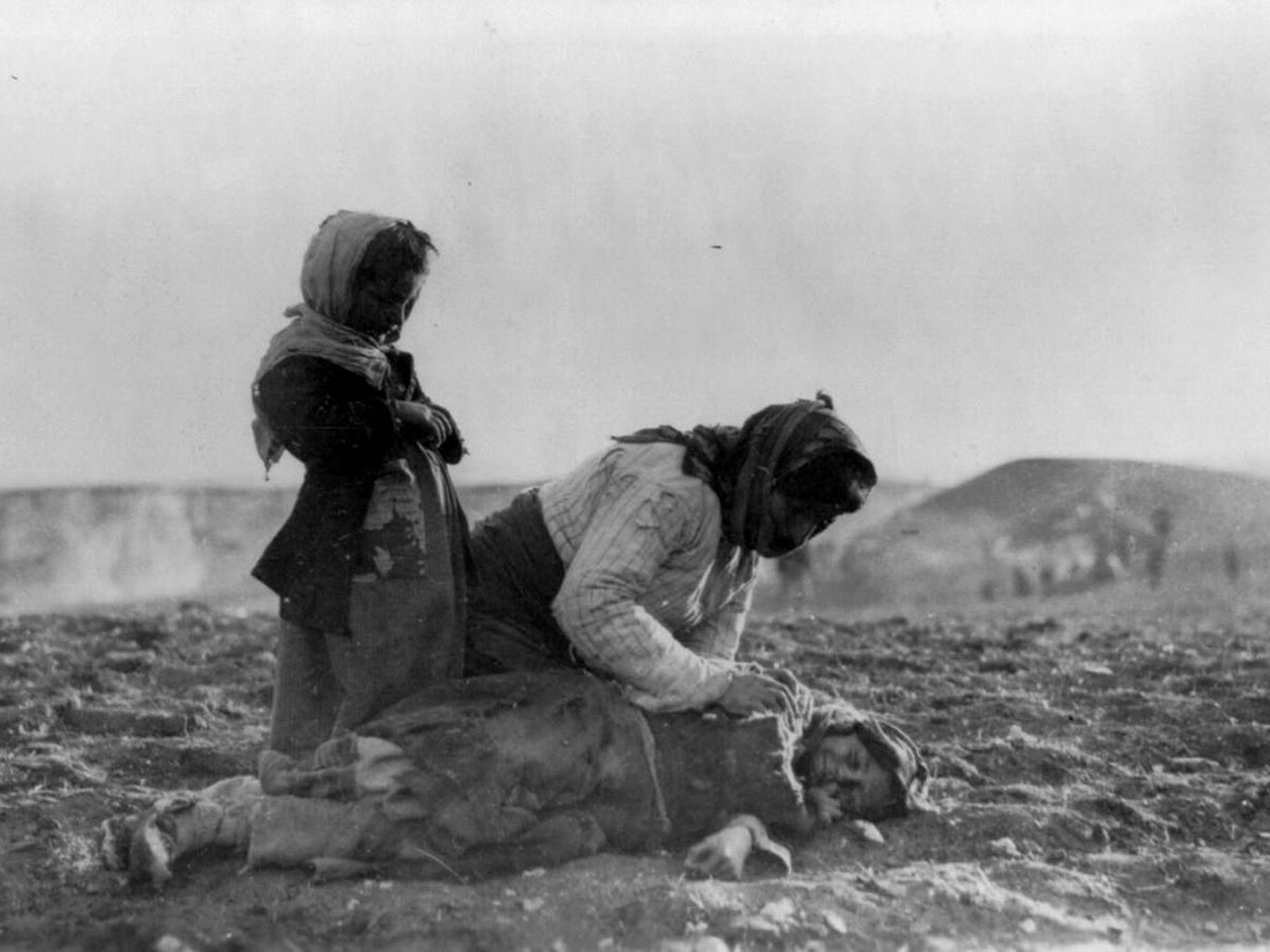 Foto: Mujer armenia arrodillada junto a un niño muerto en el campo de Alepo, Siria