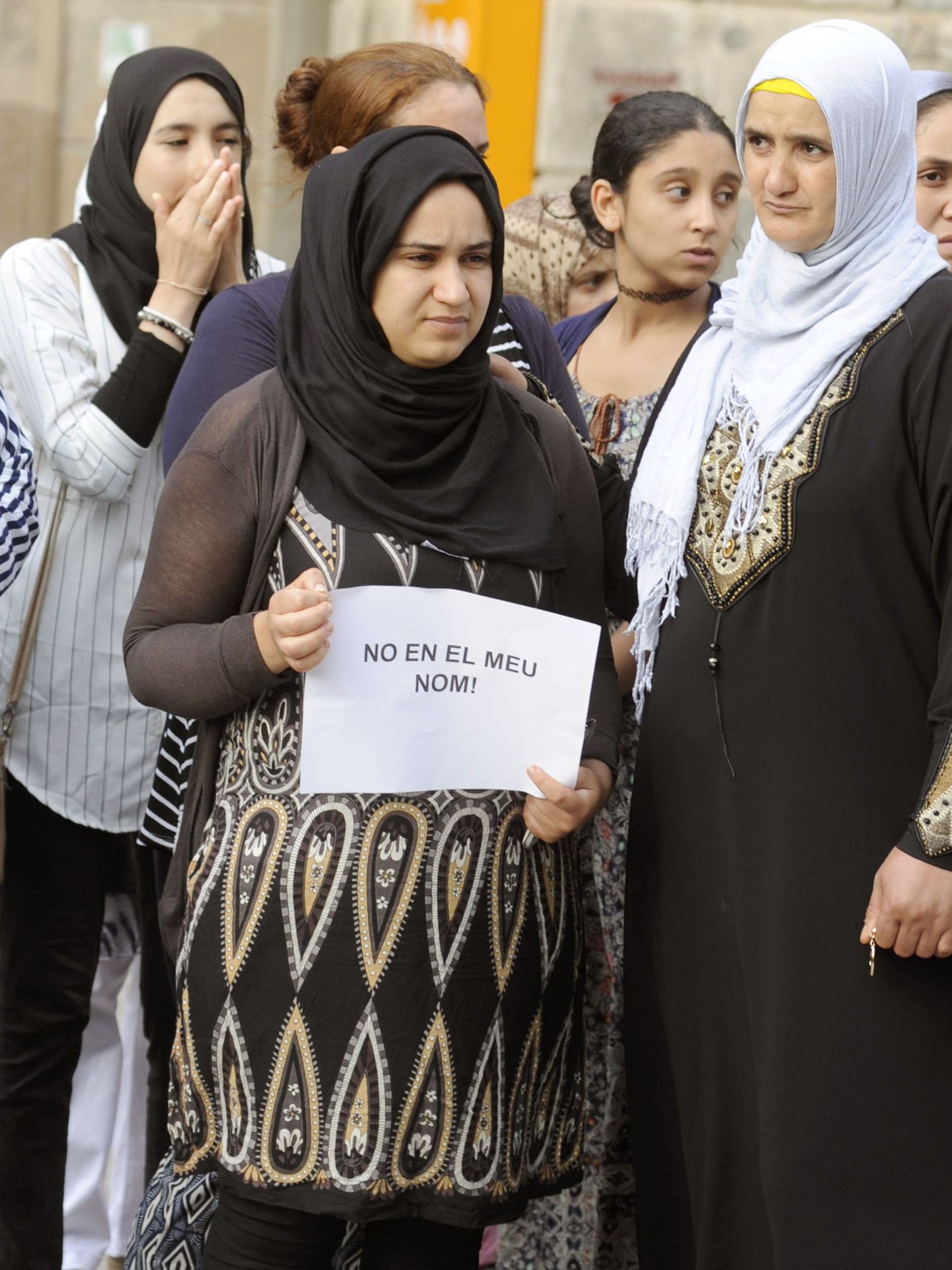 GRA337. RIPOLL (GIRONA), 19 08 2017.- Un grupo de mujeres muestran carteles que dicen 'No en mi nombre' durante el minuto de silencio que la comunidad musulmana ha llevado a cabo esta tarde delante del Ayuntamiento de Ripoll en memoria de las víctimas de los atentados de Cataluña. EFE Robin Townsend