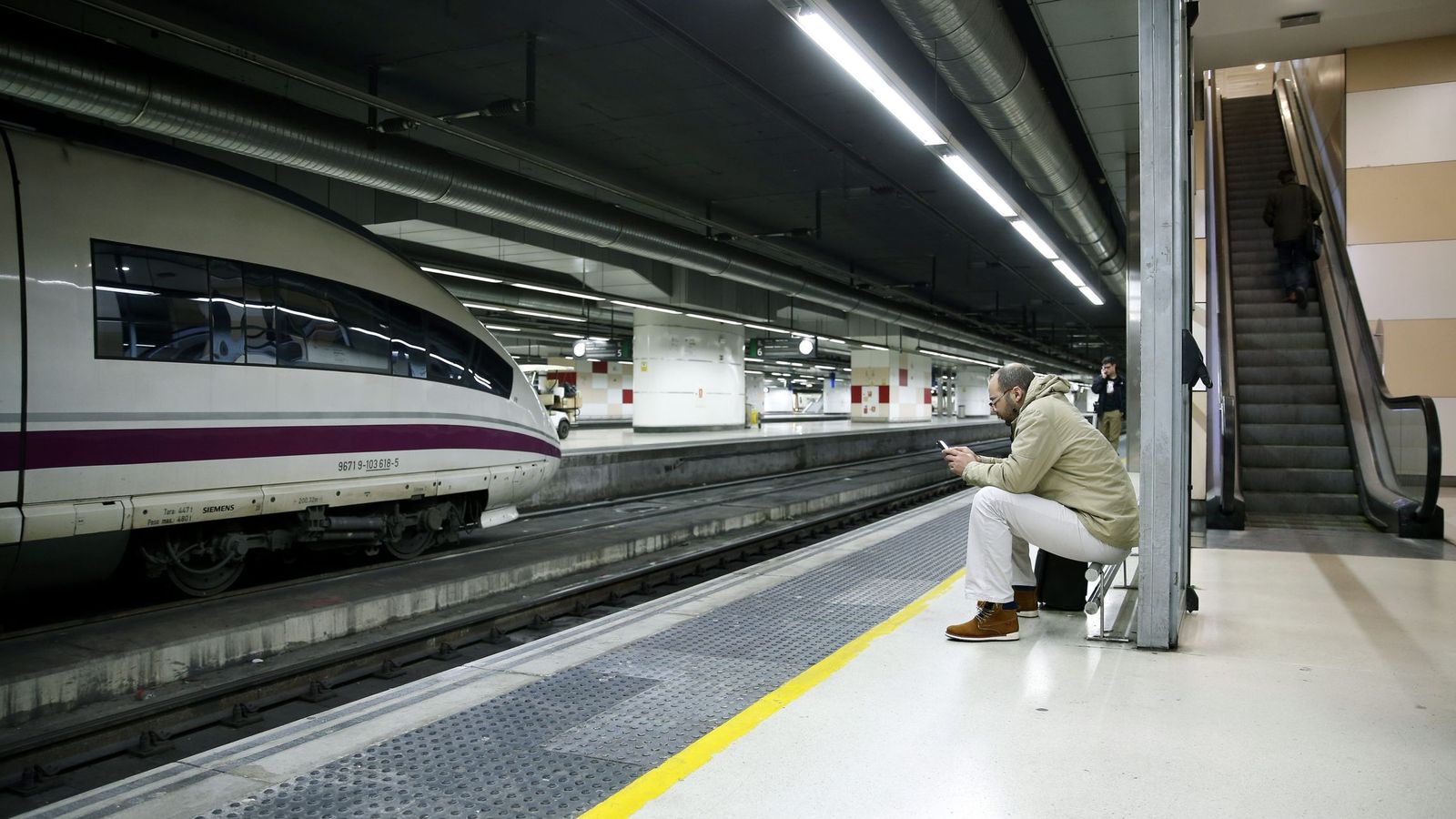 Foto: Un pasajero espera sentado a su tren en la estación de Sants, en Barcelona. (Efe)