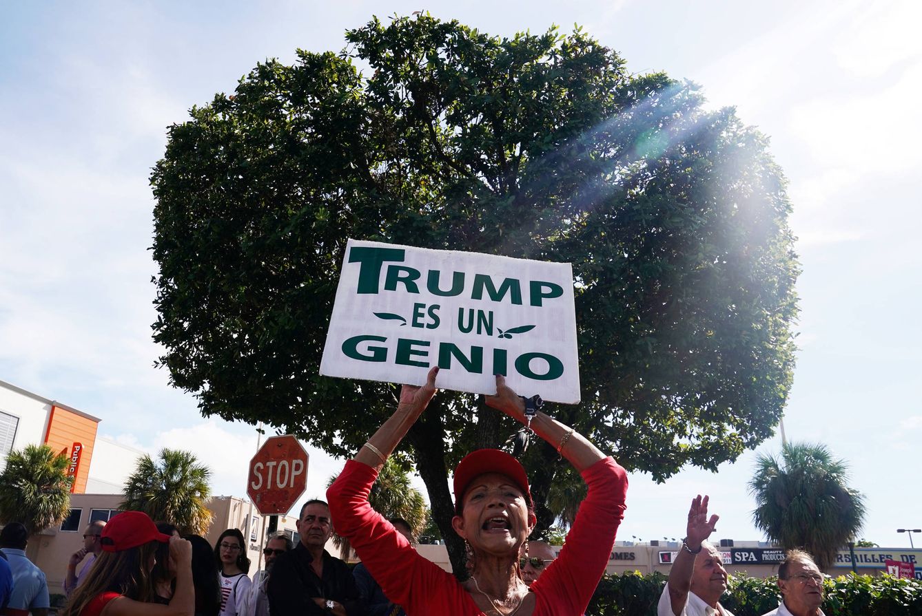 Una votante del candidato Ron DeSantis con un cartel de apoyo a Trump, en Miami, Florida. (Reuters) 