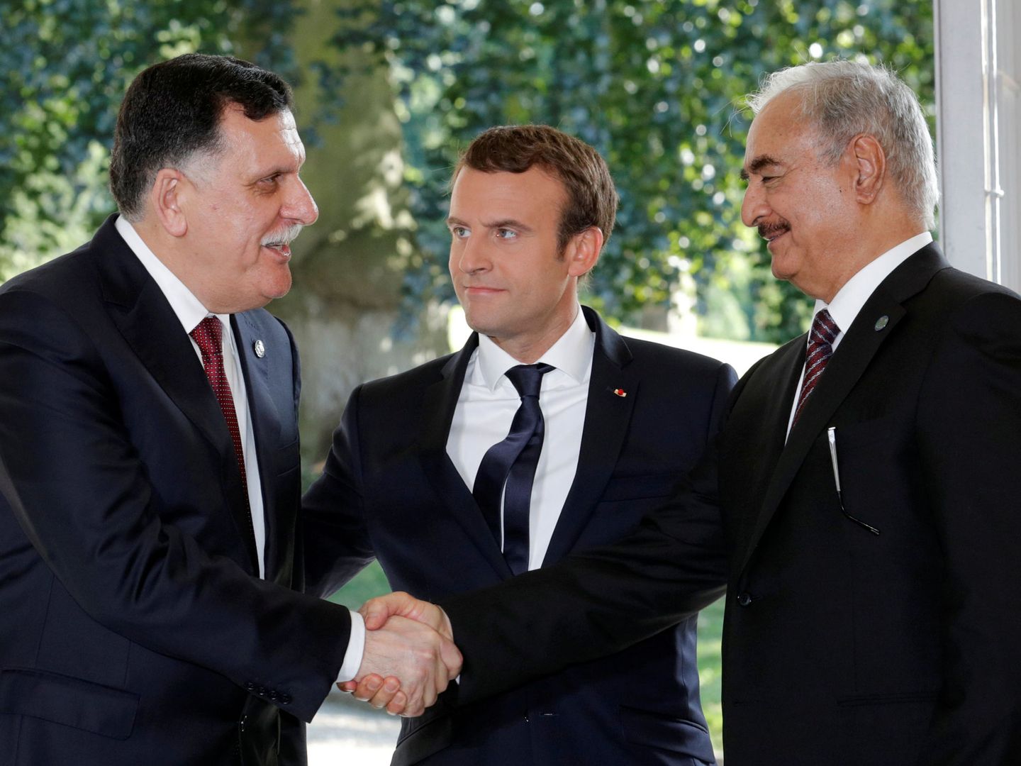 Macron reúne a los representantes de los dos gobiernos de Libia, el primer ministro, Fayez al-Sarraj, y el general Khalifa Haftar, en La Celle-Saint-Cloud, París, el 25 de julio de 2017. (Reuters)