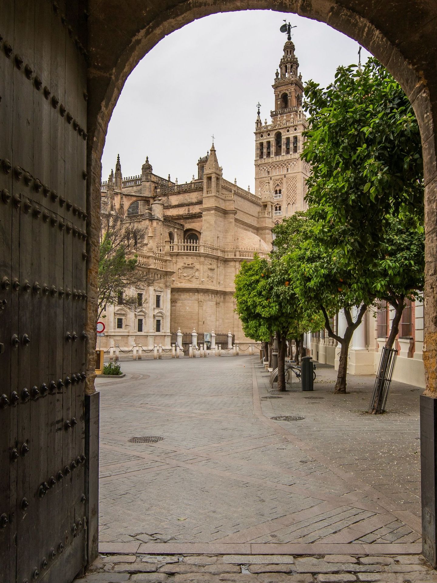 Vista de la catedral de Sevilla y la Giralda desde la puerta de entrada al patio de Banderas. (EFE/Raúl Caro)